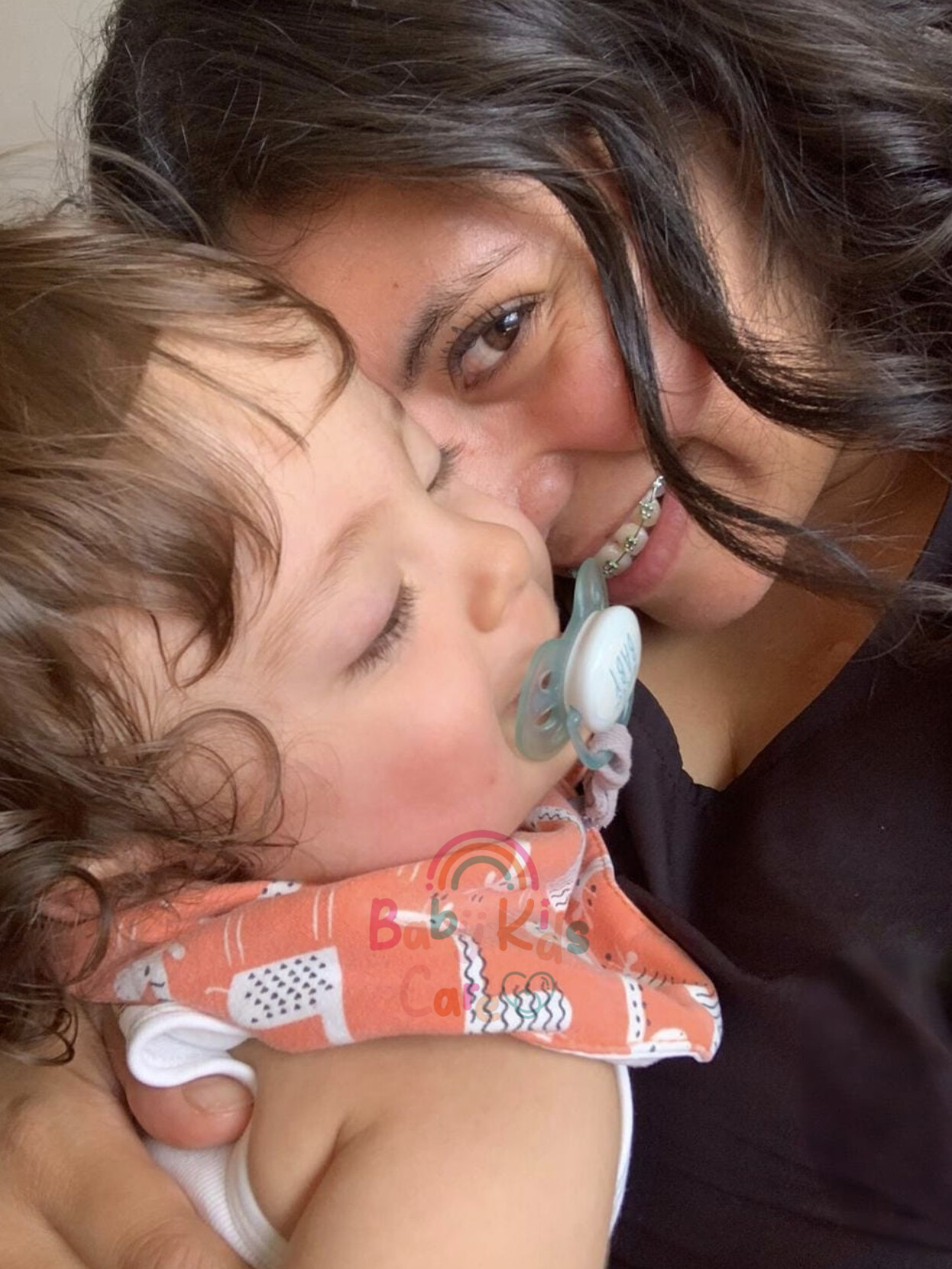 Cuidadora Baby Kids Care jugando con bebé en el suelo, estimulación temprana